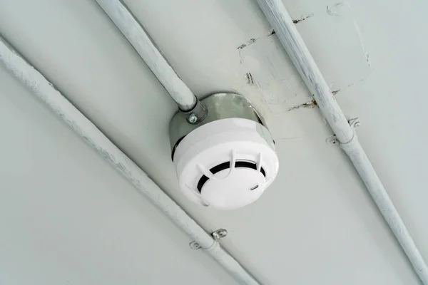 Smoke detector sensor on cement ceiling in parking area