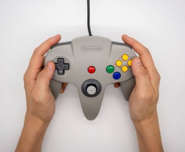 Nintendo64: Bangkok, Tayland - 12 Temmuz 2018: hodling beyaz arka plan üzerinde izole gri Nintendo 64 oyun kumandası el.
