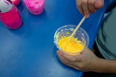 Oyun hamuru bilimsel deney yapmak için yapışkan karışımı karıştırma el evlat. Okuldan eve etkinlik.