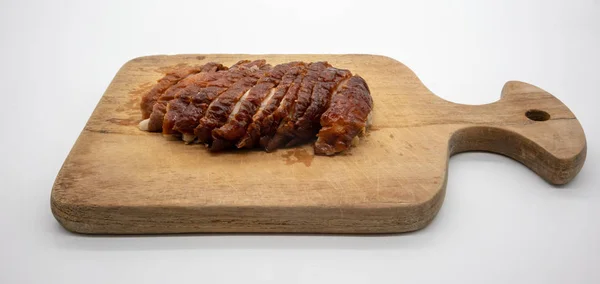 Roasted duck on wooden cutting board isolated on white background