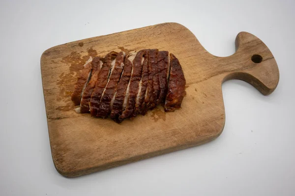 Roasted duck on wooden cutting board isolated on white background