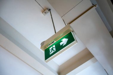 Yeşil acil çıkış işareti. Tavanda asılı kaçış yolu için Yön.
