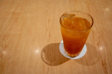 Ahşap masa üzerinde uzun bardak buzlu meyve siyah çay.