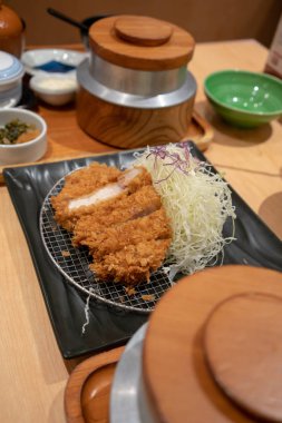 Lapa lapa panko Ekmek kırıntı ile kaplı ve peynir ile doldurulmuş derin kızarmış et pirzola kapalı Tonkatsu metal elek ve rendelenmiş lahana.