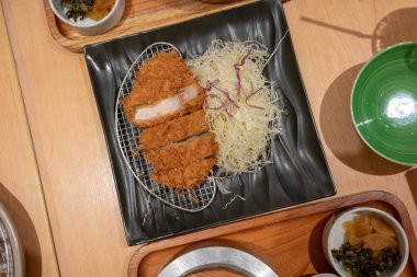 Derin kızarmış sığır filetosu domuz pirzola lapa lapa panko Ekmek kırıntı, Tonkatsu metal elek ve rendelenmiş lahana ile kaplı kadar kapalı.