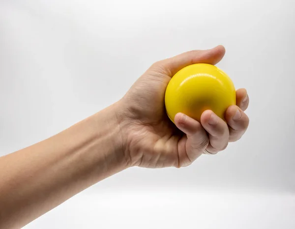 Ręka Trzyma Piłkę Żółty Stres Białym Tle — Zdjęcie stockowe