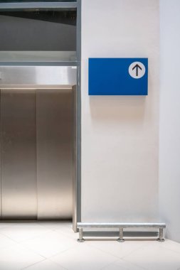 Mavi tabela Asansör önünde beyaz duvar arka plan üzerinde sahte