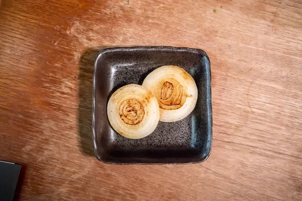 Twee Stukken Van Gegrilde Zwarte Keramische Schotel Tegen Houten Achtergrond — Stockfoto