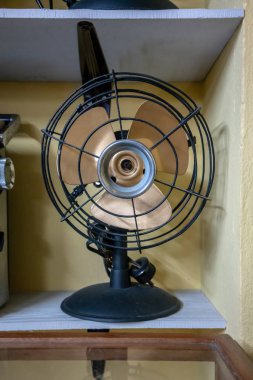 Beyaz ahşap raf açık sarı renkli karşı eski siyah vintage tarzı fan.