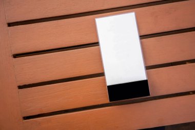 Ahşap masa arka plan üzerinde beyaz plastik menü Yönetim Kurulu.