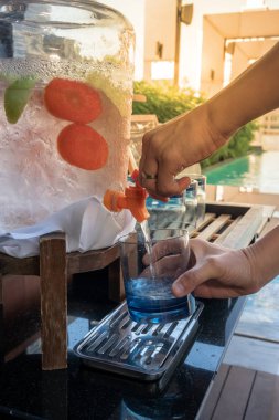 Eller kadın su infüzyon meyve ile su dağıtıcısı kolu çekerek. Ferahlık kavramı