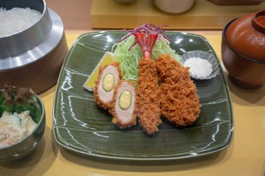 Closed up artificial model of Tonkatsu set served with rice in Japanese pot and soup for display.