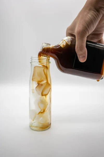 Verter Café Una Botella Vidrio Con Hielo Aislado Sobre Fondo —  Fotos de Stock