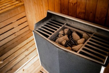 Sauna spa oda içinde sıcak taş ısıtıcı makine. Sauna taşlar / sıcak su temini için taşlar, buhar sauna, spa kavramı, sıcak gevşeme içinde taşlar üzerinde