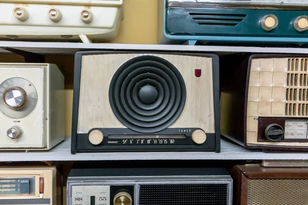 Retro broadcast radiomottagare på trähylla mot gula b — Stockfoto