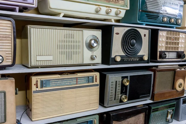 Retro uitzending radio-ontvangers op houten plank tegen gele b — Stockfoto