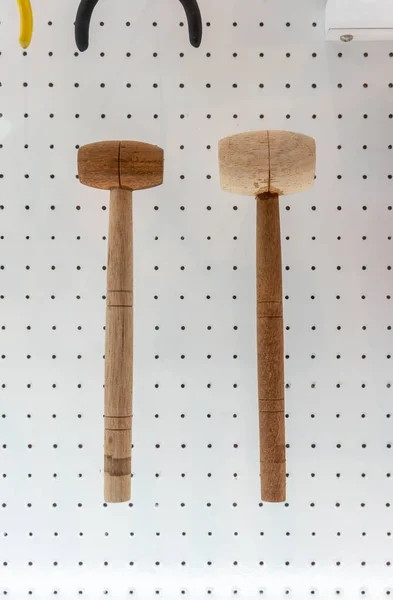 Martillos de madera colgando contra fondo de pared de punto blanco . — Foto de Stock
