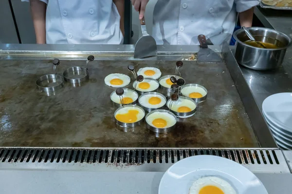 Hotel chef mãos com luvas cozinhar ovos fritos na panela quente — Fotografia de Stock