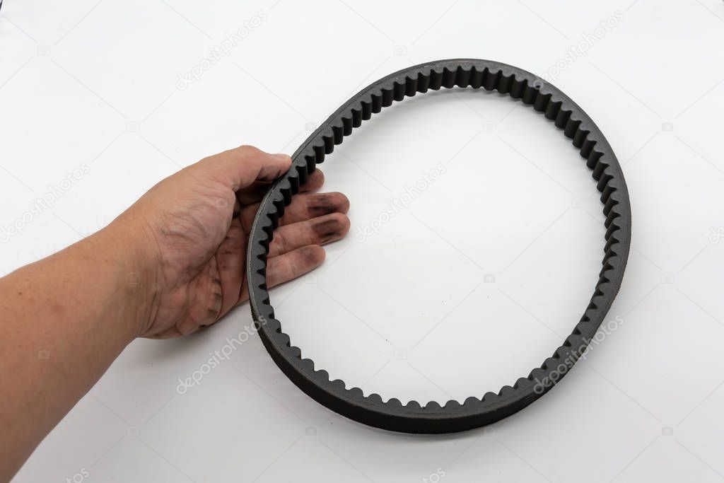 Hand holding the timing belt for motorcycle engine isolated whit