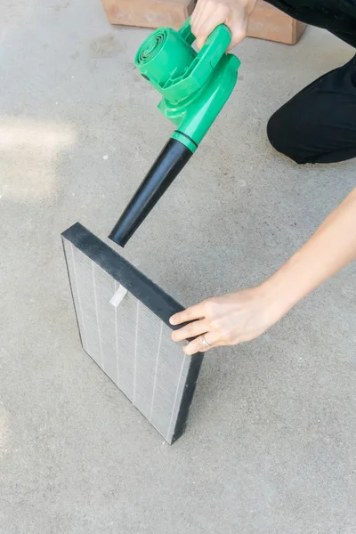 汚れた空気清浄機をきれいにする女の手持ち株送風機 — ストック写真