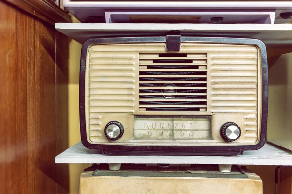 Vintage retro radio on wooden shelf. Retro technology.