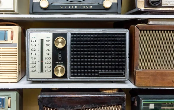 Retro uitzending radio-ontvangers op houten plank tegen gele b — Stockfoto