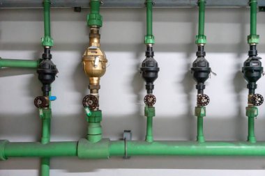 Park alanında su pompası valfi. Yeşil renkte pipping sistemi 