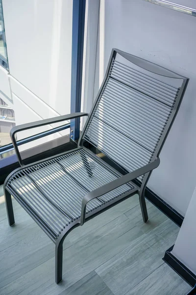 Black modern outdoor chair in wooden terrace.