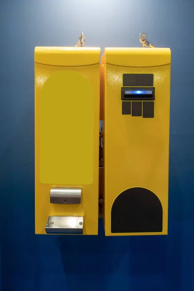 Bill changer machine in yellow color against blue. — Stock Photo, Image