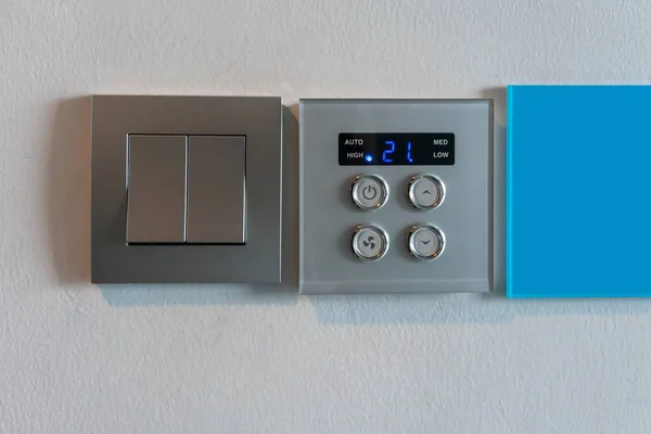 Interruptor de luz metálico gris y controlador de aire acondicionado con excavación —  Fotos de Stock