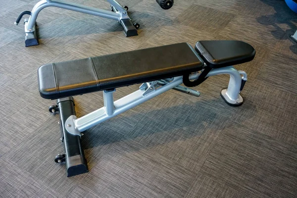 Adjustable gym bench with black leather in public gym