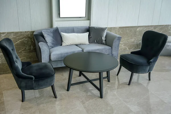 Home interior with black circle table, black chairs and gray sof