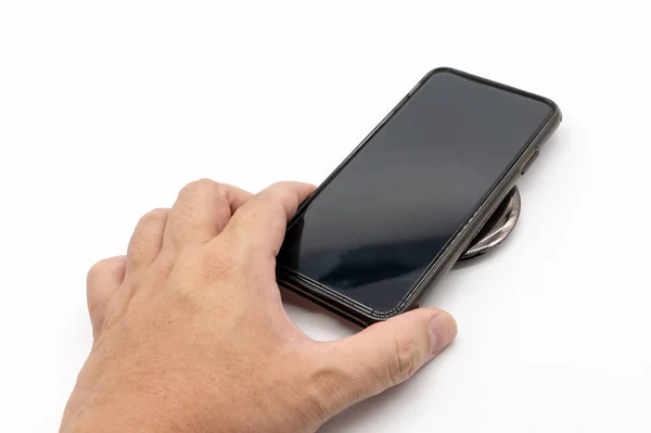 Hnad holding black mobile phone to charge on the black grossy ro — Stock Photo, Image