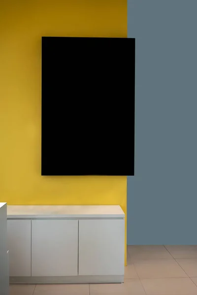 Moldura de mockup preto pendurado na parede amarela no interior moderno . — Fotografia de Stock