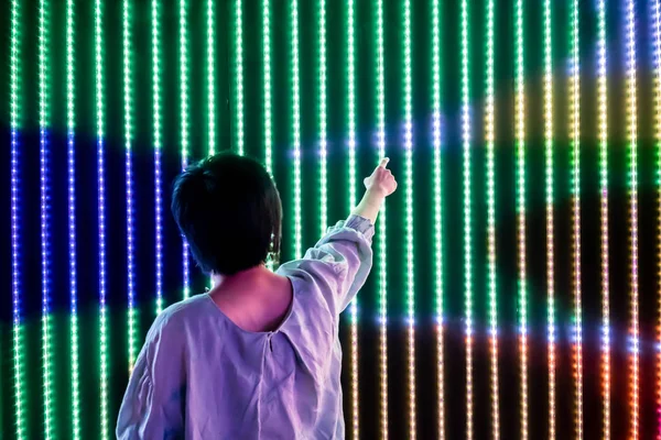 Asiatische Frau spielt mit LED-Licht Interaktionswand — Stockfoto