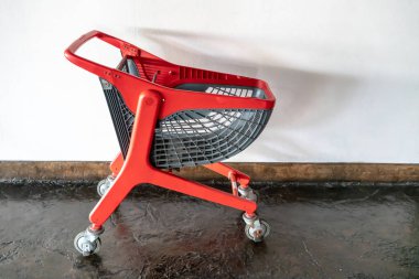 beyaz duvara karşı tekerlekler ile kırmızı modern tasarım alışveriş sepeti 