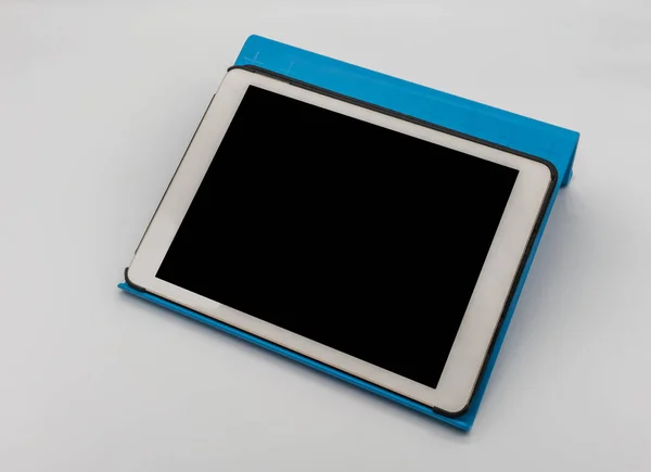 White digital tablet on blue plastic tablet stand isolated on wh — Stock Photo, Image