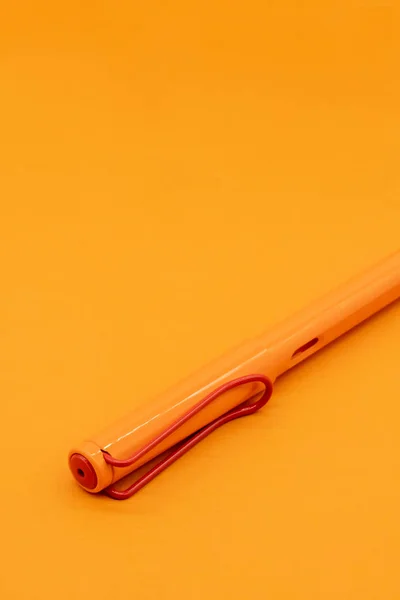 Matte oranje kalligrafische pen of vulpen op oranje achtergrond — Stockfoto