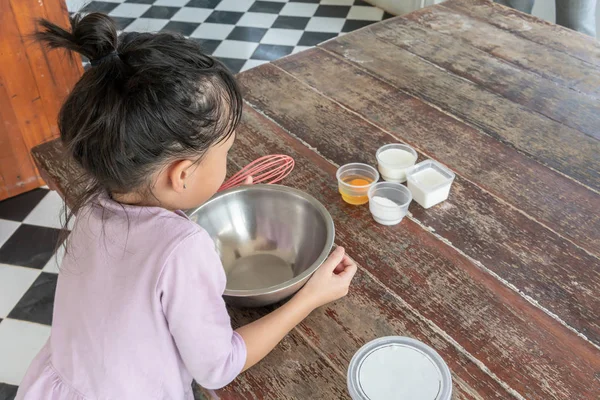 Girl paying attention on ingredients for homemade ice cream