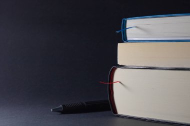 Siyah arkaplan üzerine kalem ve kitaplar
