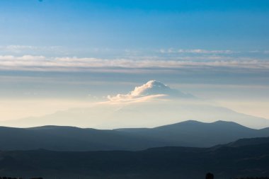 Gün doğumunda bulut kaplı dağ zirvesi