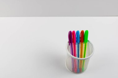 Beyaz arkaplandaki kalem kutusunda renkli kalemler