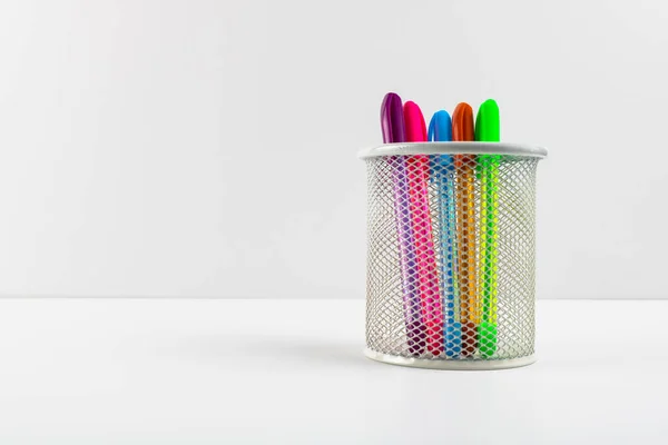 Colorful pens in the pen box on white background