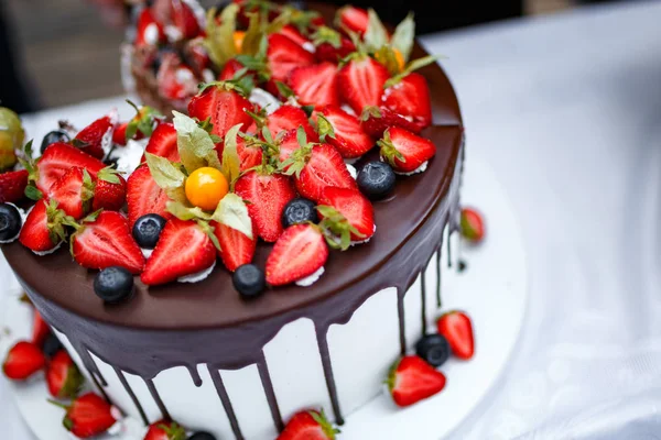 Beyaz masa örtüsü üzerine çikolata krema ile çilekli pasta.