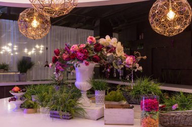 Tablo güzel çiçeklerle bezenmiştir. Tablonun üst kısmındaki, yuvarlak bir avize.