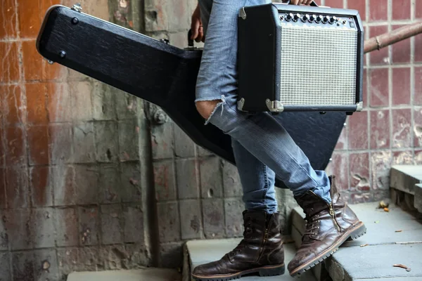 Bir vaka bir gitar ve amfi ile tutarak Sokak müzisyeni. Serseri bir yaşam tarzı. Para kazanmaya oynuyorum. İşsiz müzisyen. Gelecekteki rock yıldızı. Yatay olarak çerçeveli atış.