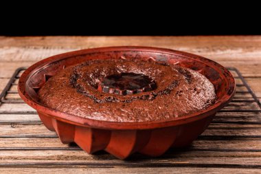 Ahşap bir masa üzerinde bir demir ızgara üzerinde çikolatalı kek.