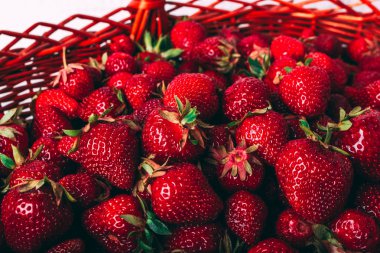 Hasır sepet ile olgun çilek dolu. Beyaz ahşap zemin üzerinde. Yakın çekim.