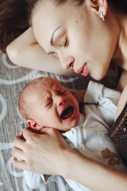 Yeni doğanların birlikte yatakta kadın yalan. Anne ve bebek. Çocuk çığlıklar ve çığlıkları. Annesi onu sakinleştirmeye çalışır. Aile hayatı. Adam doğdu.