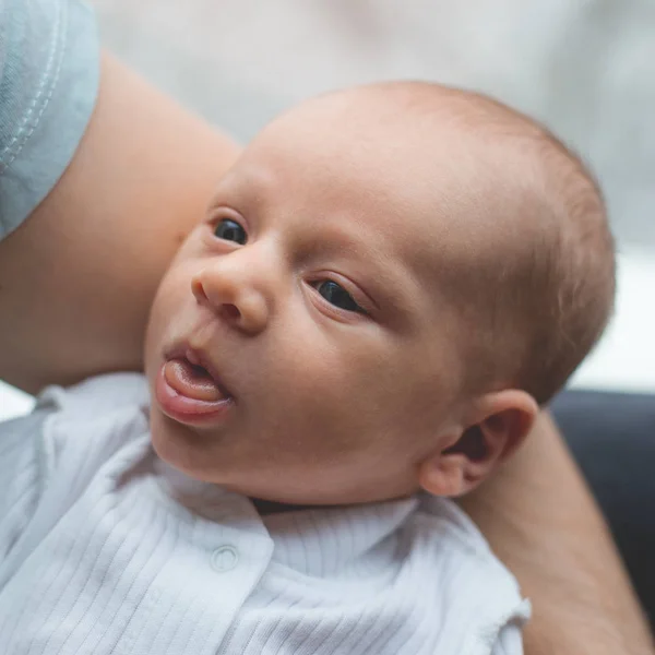 Ellerinde yeni doğmuş bir bebek tutan adam. Çocuk dili gösterir. Mutlu aile hayatı. Adam doğdu.